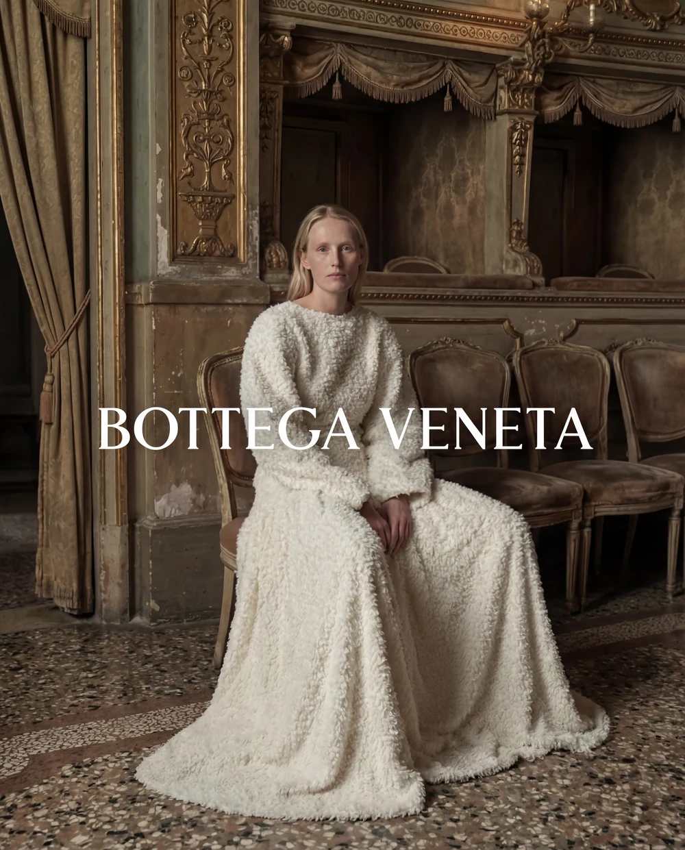 Woman in a pale dress seated in an ornate historic interior