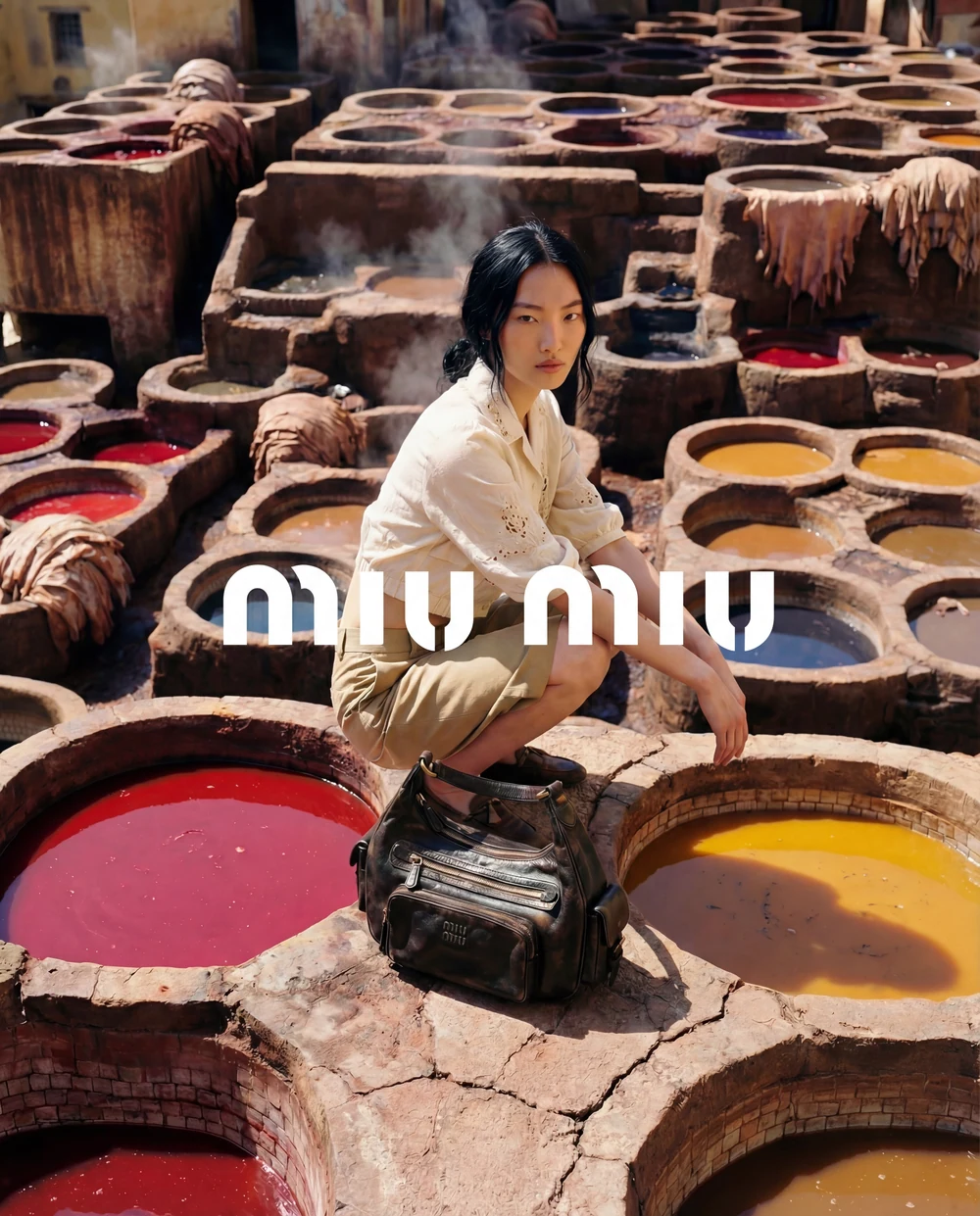 Woman with a dark handbag amongst the coloured vats of a traditional tannery